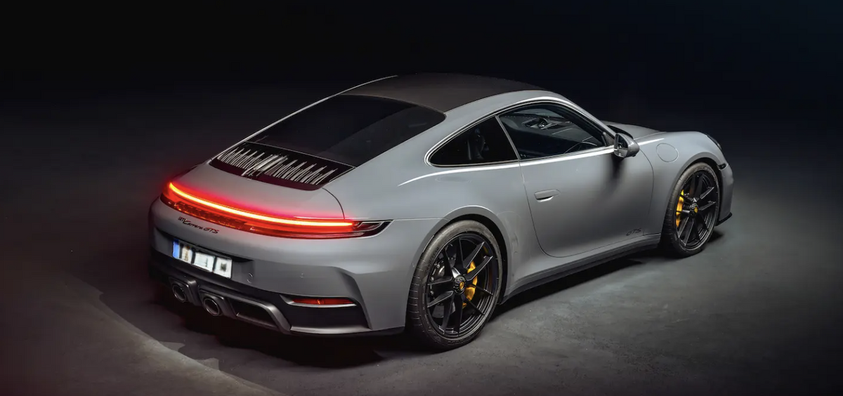 Porsche car parts displayed on a sleek gray Porsche 911 Carrera GTS from a rear angle.