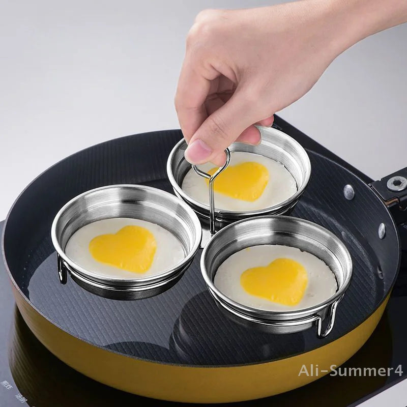 Stainless Steel Egg Poacher cooking three heart-shaped eggs on a pan for a delightful meal.