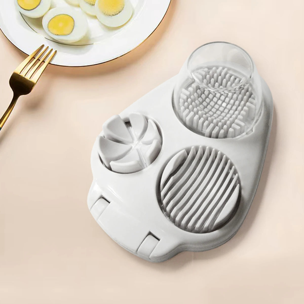 3-in-1 egg cutting tool on a kitchen counter, showcasing its slicer, cracker, and cutter functionalities.