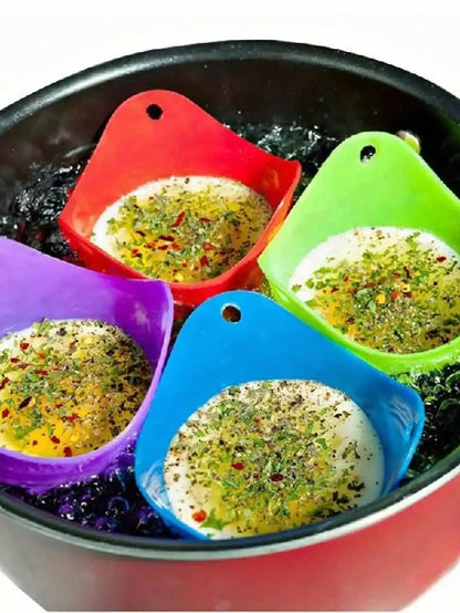 4 pcs silicone poached egg cups in random colors boiling in a pot with herbs and spices on top.