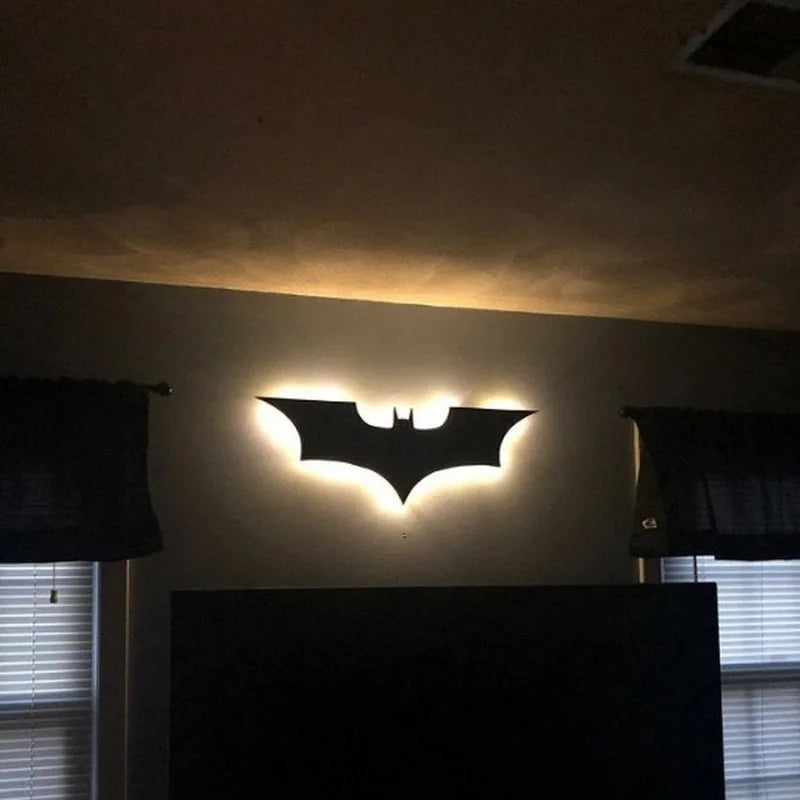 Colorful LED night light wall lamp shaped like a bat, providing ambient lighting in a room.