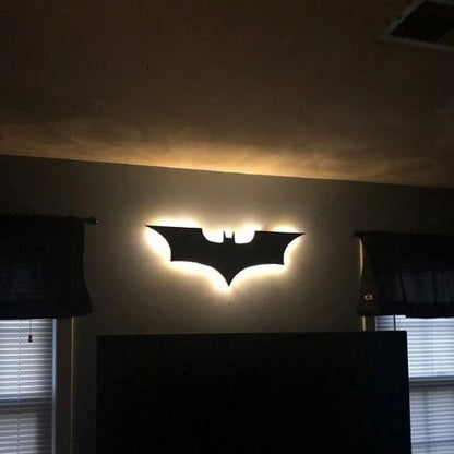 Colorful LED night light wall lamp shaped like a bat, providing ambient lighting in a room.