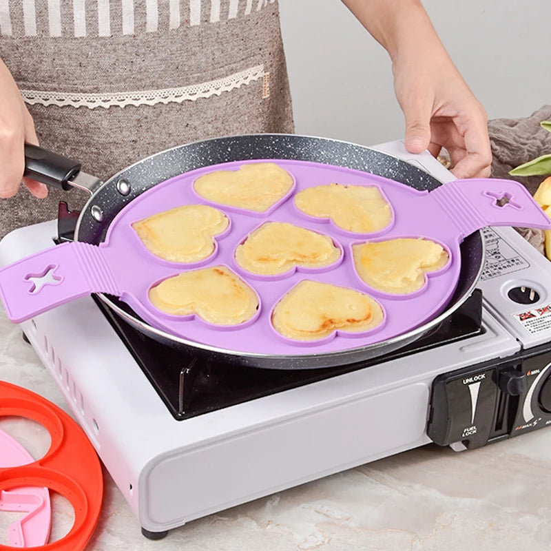Nonstick silicone pancake ring making heart-shaped pancakes on a stovetop, ideal for fun breakfasts.